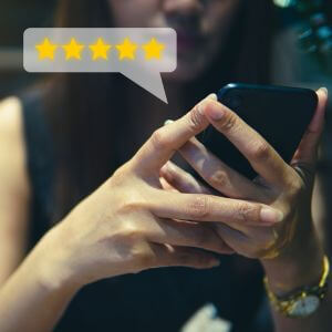 El cliente revisa el concepto de buena calificación, las personas usan teléfonos inteligentes con el ícono de cinco estrellas y testimonios positivos de los clientes.