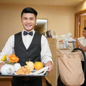 Retrato de sonriente camarero vietnamita y camarera en el fondo